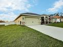 Exterior showcasing a well-manicured lawn and attached garage, blending comfort and convenience at 1034 Se 65Th Cir, Ocala, FL 34472