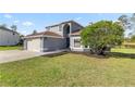 Charming two-story home with an arched entryway and a spacious front lawn at 10910 Sw 47Th Ct, Ocala, FL 34476