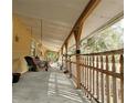 Inviting covered porch featuring a wooden swing and railing, perfect for enjoying the outdoors at 1370 Nw 120Th Ave, Ocala, FL 34482