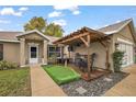 Inviting front porch featuring a pergola with an entertainment area and decorative putting green at 33827 Silver Pine Dr, Leesburg, FL 34788