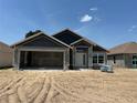 Image of an unfinished home with a large two car garage and visible construction materials at 4413 Sw 90Th Pl, Ocala, FL 34476