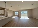 Open concept living area with bright lighting, light wood flooring, and sliding glass doors at 9975 Sw 39Th Ter, Ocala, FL 34476