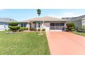 Charming single-story home features a well-manicured lawn and a painted driveway at 1913 Augustine Dr, The Villages, FL 32159