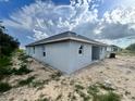 View of single story home with gray exterior, a covered patio, and a well maintained yard at 4365 Sw 90Th Pl, Ocala, FL 34476