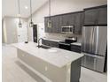 Gourmet kitchen with large island, stainless steel appliances, and modern pendant lighting at 6150 Sw 123 Ave Rd, Dunnellon, FL 34432
