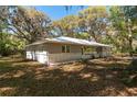Charming single-story home with mature trees, brick foundation, and light gray paint color at 14100 Ne 40Th Ct, Anthony, FL 32617