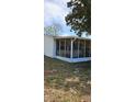 A view of the exterior showing the enclosed screened porch of the home at 10934 Luana Dr, Leesburg, FL 34788