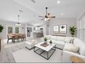 Spacious living room with dining area, kitchen, white couch and modern decor at 44 Cedar Tree Dr, Ocala, FL 34472