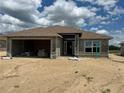 Unfinished exterior with attached garage and block construction under a cloudy sky at 4516 Sw 90Th Lane Rd, Ocala, FL 34476