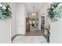 Inviting entryway features wood-look tile flooring, a grandfather clock, and views into the living spaces at 9307 San Jose Blvd, Howey In The Hills, FL 34737