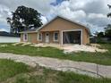 New construction home with light tan exterior, white trim, attached garage, and landscaping in progress at 2147 Sw 3Rd St, Ocala, FL 34471
