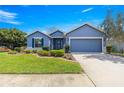 Beautiful blue single-story home with a well-kept lawn, landscaped garden beds, and an attached garage at 9230 Sw 66Th Loop, Ocala, FL 34481
