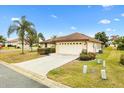 Well maintained lawn, shrubs and a palm tree compliment this single story home with a two car garage at 12240 Se 172Nd Ln, Summerfield, FL 34491