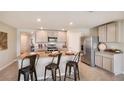 A modern kitchen with granite countertops, stainless steel appliances, and a breakfast bar with seating at 13709 Sw 42Nd Ave, Ocala, FL 34473