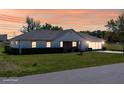 Charming single-story home featuring a well-manicured lawn and beautiful sunset sky at 3275 Nw 44Th Ct, Ocala, FL 34482