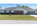 Well-maintained single-story home with a two-car garage, lawn, and manicured landscaping at 3275 Nw 44Th Ct, Ocala, FL 34482