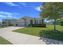 Charming single-Gathering home with a well-manicured lawn, lush landscaping, and a three-car garage at 5048 Sw 57Th Pl, Ocala, FL 34474