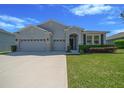 Charming single-Gathering home with a well-manicured lawn and a three-car garage on a sunny day at 5048 Sw 57Th Pl, Ocala, FL 34474