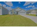 Inviting single-story house featuring lush green lawn and a two-car attached garage at 6933 Se 111Th Ln, Belleview, FL 34420