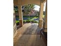 Charming front porch with brick pavers, stone accents, and a view of the blooming tree at 8344 Sw 79Th Cir, Ocala, FL 34476