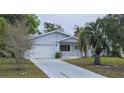 Well-maintained single-story home with an attached garage, beautiful landscaping, and a long driveway at 8449 Sw 106Th Pl, Ocala, FL 34481
