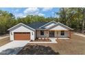 Attractive single-Gathering home featuring a modern design, attached garage, and landscaped front yard at 8850 Sw 125Th Ter, Dunnellon, FL 34432