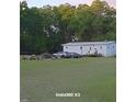 Exterior of a manufactured home with two cars in the front yard at 10750 Nw 7Th St, Ocala, FL 34482