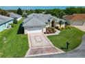 Beautiful single-story home with a well-maintained lawn, attached two-car garage, and a charming front garden at 11010 Se 174Th Loop, Summerfield, FL 34491