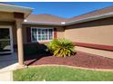 Inviting front entrance with decorative landscaping, colorful rock mulch, and covered entryway at 11395 Sw 139Th St, Dunnellon, FL 34432
