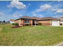 Charming single-story home with well-manicured lawn and garden beds with brown mulch at 11395 Sw 139Th St, Dunnellon, FL 34432