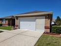 Attached one-car garage featuring a concrete driveway and well-maintained landscaping at 11395 Sw 139Th St, Dunnellon, FL 34432
