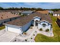 Aerial view of a light blue home with a brown shingled roof in a residential community at 1813 Sw 157Th Place Rd, Ocala, FL 34473