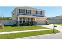 Two-story home with a two-car garage, covered front porch, manicured lawn, and neutral color palette at 1861 Ne 50Th Ter, Ocala, FL 34470