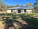 A spacious backyard featuring a lush green lawn and sliding glass doors at 22 Fisher Way Pass, Ocklawaha, FL 32179