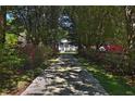 Long driveway through trees and flowers leads to a charming two-story home with a beautiful garden at 2881 Se 41St Pl, Ocala, FL 34480