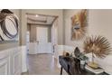 Elegant entryway with decor art, console table, stylish mirror, and neutral wall paneling at 3067 Canopy Oak Blvd, Wildwood, FL 34785