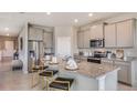Modern kitchen with granite countertops, stainless steel appliances, and a cozy breakfast bar at 3067 Canopy Oak Blvd, Wildwood, FL 34785