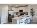 Modern kitchen boasts white cabinets, quartz countertops, and stainless steel appliances at 3282 Bertram Rd, Wildwood, FL 34785