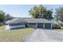 A sunny shot of a one story house, featuring a two-car garage and a well-manicured lawn at 390 Sw Shorewood Dr, Dunnellon, FL 34431
