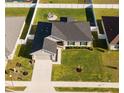 Aerial view of a single-story home showcasing dark-grey roof, green lawn, and backyard seating area at 5001 Sw 91St Pl, Ocala, FL 34476
