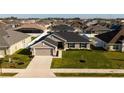 Charming single-story home featuring a well-manicured lawn, attached two-car garage and dark-grey roof at 5001 Sw 91St Pl, Ocala, FL 34476