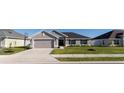Charming single-story home features a two-car garage and a well-maintained lawn, enhancing its curb appeal at 5001 Sw 91St Pl, Ocala, FL 34476