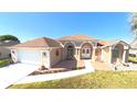 Inviting home featuring a well-manicured lawn, arched entryway, and an attached two-car garage at 5291 Nw 20 Pl, Ocala, FL 34482