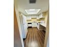 Bright kitchen with white appliances and cabinets, wood flooring, and a skylight providing natural light at 584 Bahia Cir # B, Ocala, FL 34472