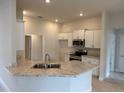 Bright kitchen featuring a granite countertop, stainless steel microwave, and ample cabinet space at 71 Nw 42Nd Pl, Ocala, FL 34475