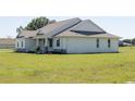 Exterior side view of the one-story home featuring a well-manicured lawn at 8214 Nw 17Th Cir, Ocala, FL 34475