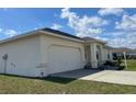 Side view of a single story house featuring an attached garage and stucco exterior finish at 8386 Sw 136Th Pl, Ocala, FL 34473