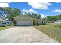 Exterior of single-story home featuring a two-car garage and walkway with a well-maintained front yard and driveway at 9300 Se 161St St, Summerfield, FL 34491