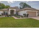 Attractive single-story home boasting a three-car garage and a beautifully landscaped front yard at 9509 Se 124Th Loop, Summerfield, FL 34491