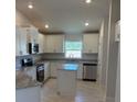 Modern kitchen with white cabinets, stainless steel appliances, and a granite countertop island at 2166 Nw 23Rd Loop, Ocala, FL 34475